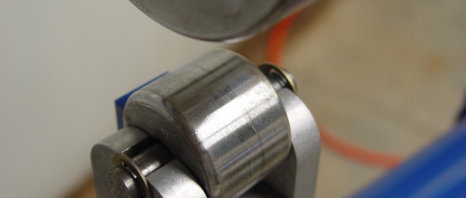 The large flat upper wheel presses the metal between the lower crowned tooling die. These dies are available in many different radii, from flat to smaller than 2” crown.