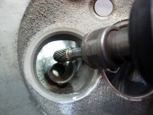 10.The valve guides are reshaped using the electric grinder, controlling the speed with the foot control. Clean up the guide until the iron is blended smooth to the opening. Use a 1\2” tip for the intake and 3\8” tip for the exhaust bowls.