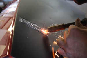 05.You want to use short bursts when welding up the holes. The thin sheet metal will warp quickly. Once the metal cools, we ground it down with a die-grinder.