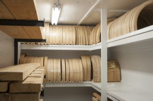 Wooden blanks are kept in a climate controlled room to preserve the dryness of the hickory wood. The half circles are blanks for felloes, which is the wooden rim that attaches to the outer steel rim.